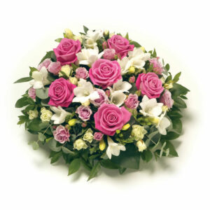 Som en rund blomsterkudde, med blommor i mjuka färger, är rosa och vitt. Beställ begravningsdekorationen online hos Euroflorist!