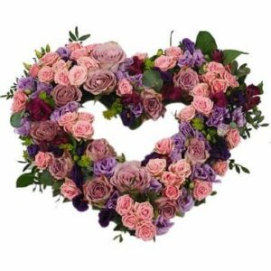 Vackert begravningshjärta med rosa och lila snittblommor tillsammans med grönt. Hjärtat finns bland begravningsblommorna hos Florister i Sverige.