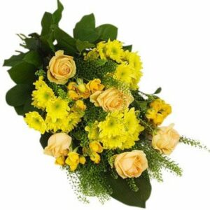 Liggande sorgdekoration med blandade gula blommor och gröna blad. Blommorna finns att beställa som blombud hos Florister i Sverige.