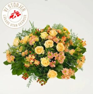 Rund begravningsdekoration fylld med mängder av blommor i aprikost och orange. Dekorationen finns att beställa som blomsterbud i Interfloras e-butik.