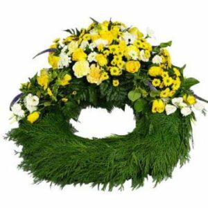 Grön begravningskrans med blandade blommor i gult och vitt på ena sidan, arrangerade i en vacker "kulle". Beställ online hos Florister i Sverige!