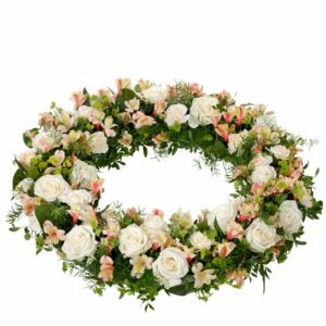 Mycket vacker rundbunden begravningskrans med cremefärgade och aprikosa blommor. Beställ hos Interflora!